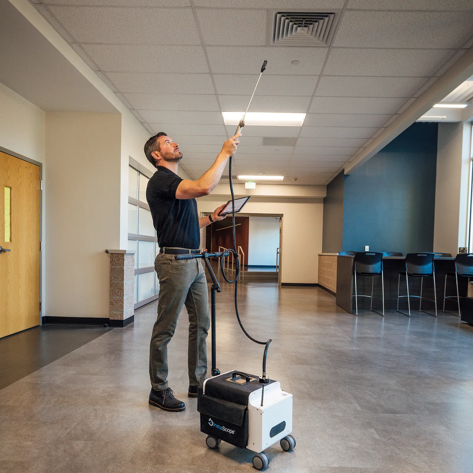 Technician scanning a ceiling vent for mold with the InstaScope