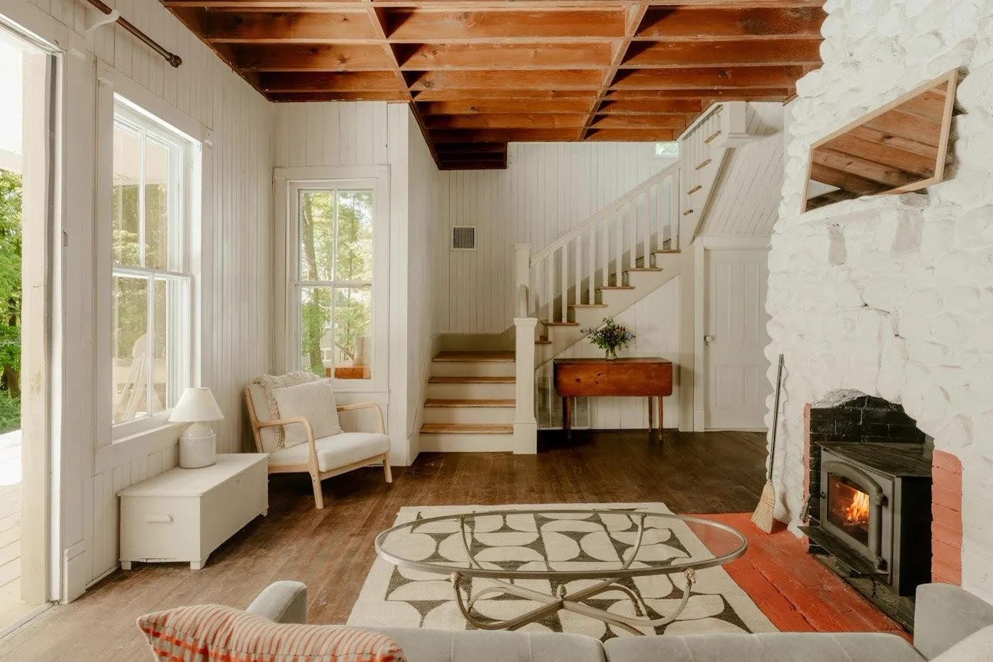 Living room with exposed ceiling beams and a fireplace.