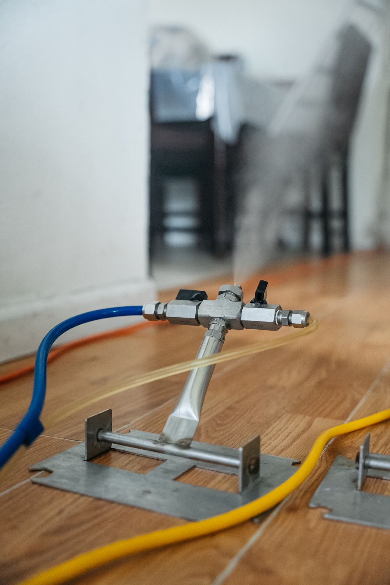 Dry-fog applicator head on a hardwood floor during treatment